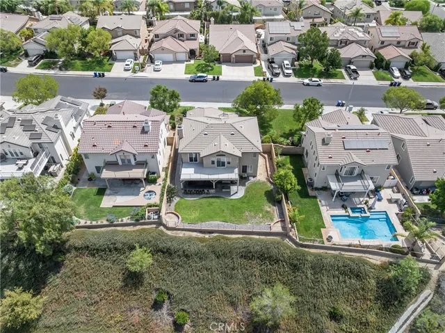 an aerial view of residential houses with outdoor space and parking