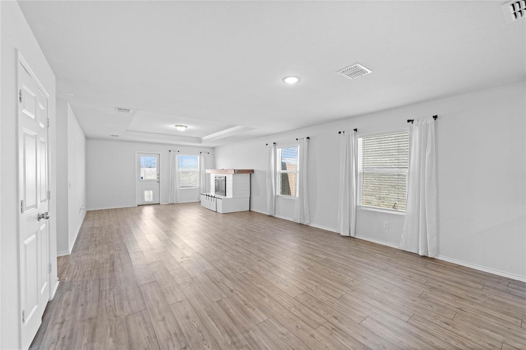 4432 Sagecroft Road Fort Worth, TX 76036 - Photo 5 of 16 Unfurnished living room with a raised ceiling and light wood finished floors