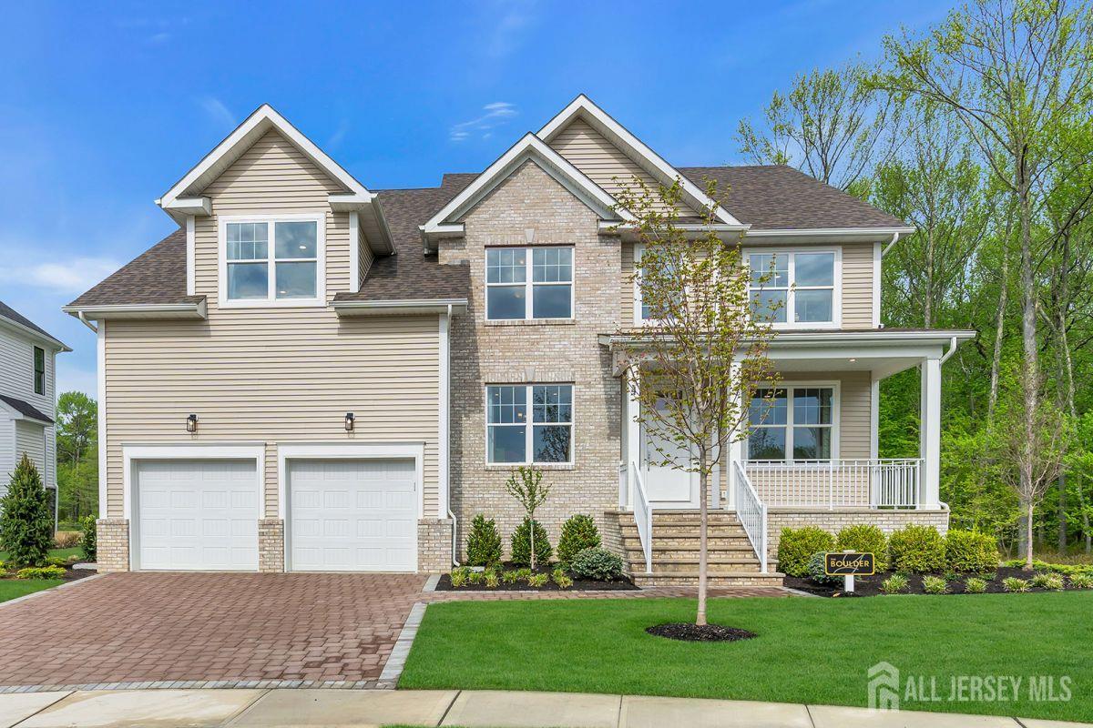 a front view of a house with a yard and trees
