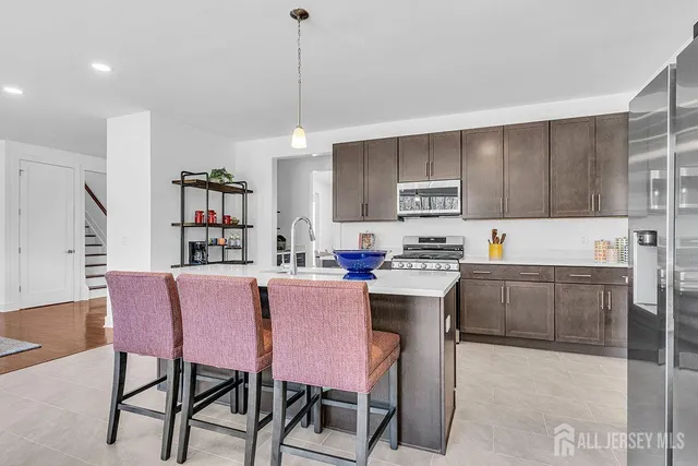 a kitchen with a dining table chairs and white cabinets