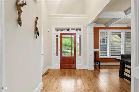 a kitchen with stainless steel appliances granite countertop a refrigerator a sink dishwasher a stove and a dining table with wooden floor