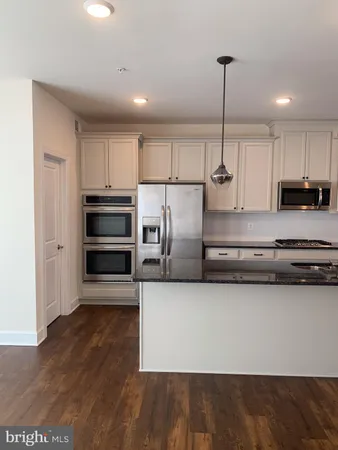 a kitchen with stainless steel appliances a refrigerator and a stove top oven