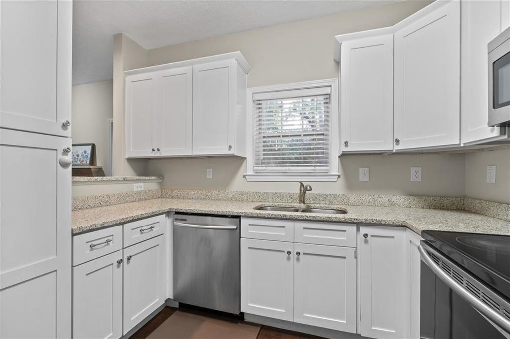 2680 Pine Tree Road Northeast, Unit 5 Atlanta, GA 30324 - Photo 13 of 32 a kitchen with white cabinets appliances a sink and a window