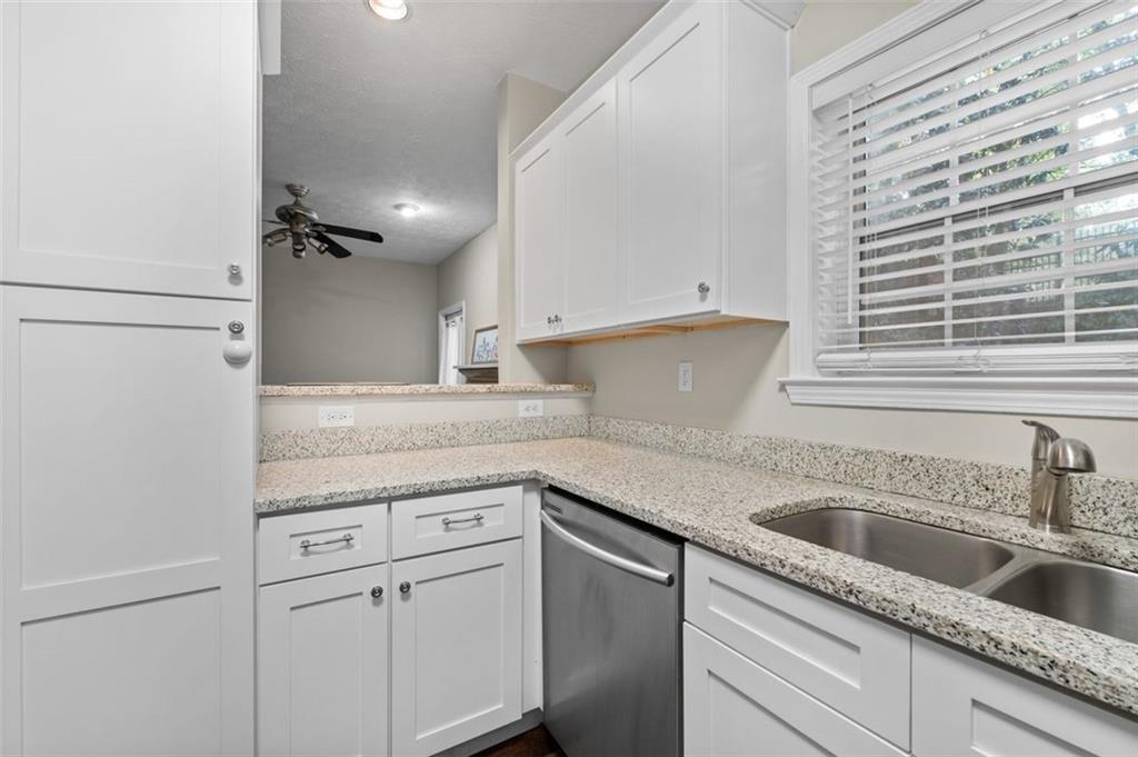2680 Pine Tree Road Northeast, Unit 5 Atlanta, GA 30324 - Photo 14 of 32 a kitchen with granite countertop a sink and cabinets