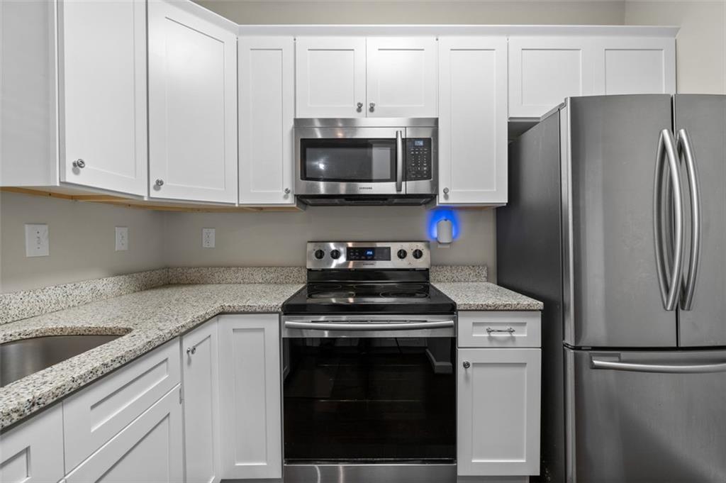 2680 Pine Tree Road Northeast, Unit 5 Atlanta, GA 30324 - Photo 15 of 32 a kitchen with a stove microwave and refrigerator