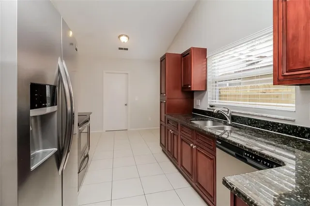 a kitchen with stainless steel appliances granite countertop a refrigerator and a sink