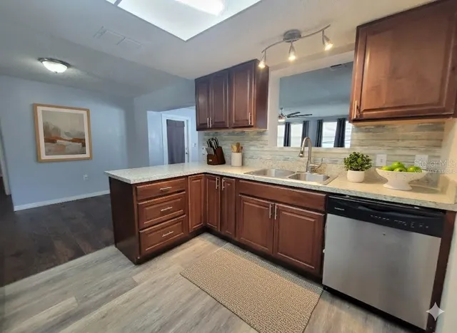 a kitchen with stainless steel appliances granite countertop wooden cabinets a sink and dishwasher