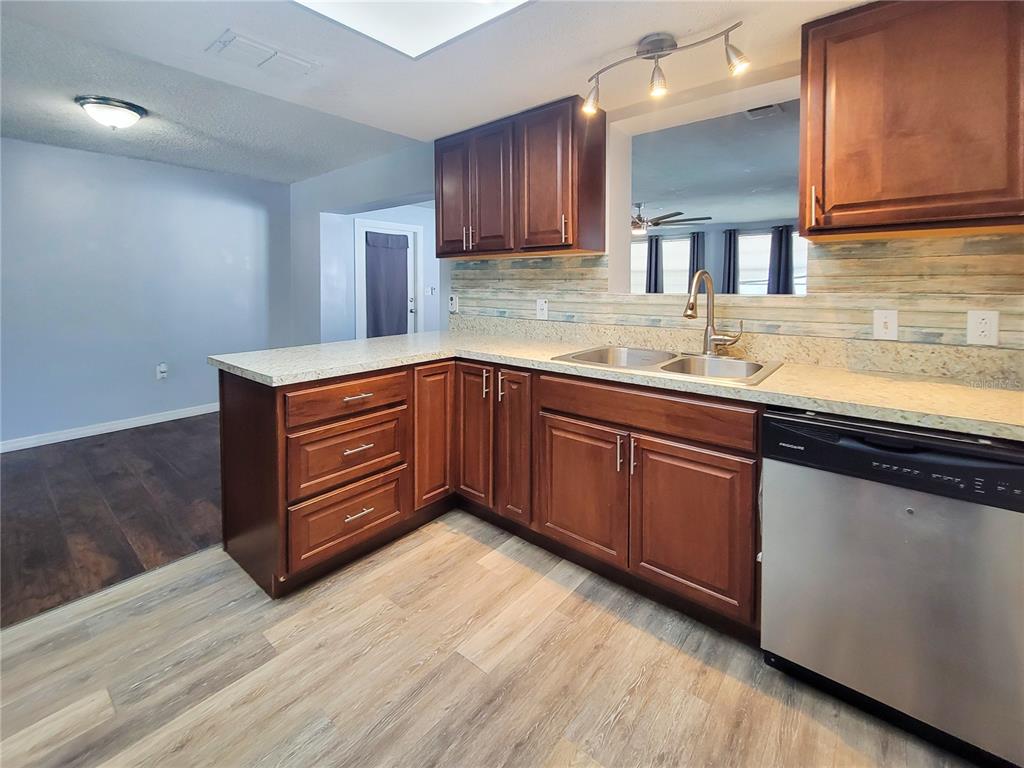 12427 Willow Tree Avenue Hudson, FL 34669 - Photo 12 of 27 a kitchen with stainless steel appliances granite countertop wooden cabinets a sink and dishwasher
