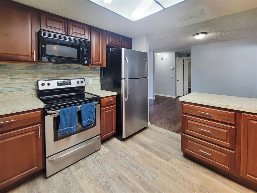 12427 Willow Tree Avenue Hudson, FL 34669 - Photo 13 of 27 a kitchen with a stove microwave and refrigerator