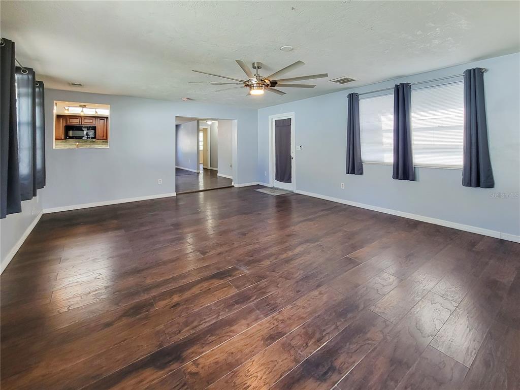 12427 Willow Tree Avenue Hudson, FL 34669 - Photo 15 of 27 a view of an empty room with wooden floor and a window