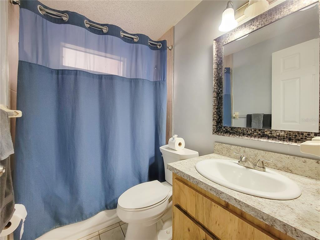12427 Willow Tree Avenue Hudson, FL 34669 - Photo 23 of 27 a bathroom with a toilet a sink and a mirror