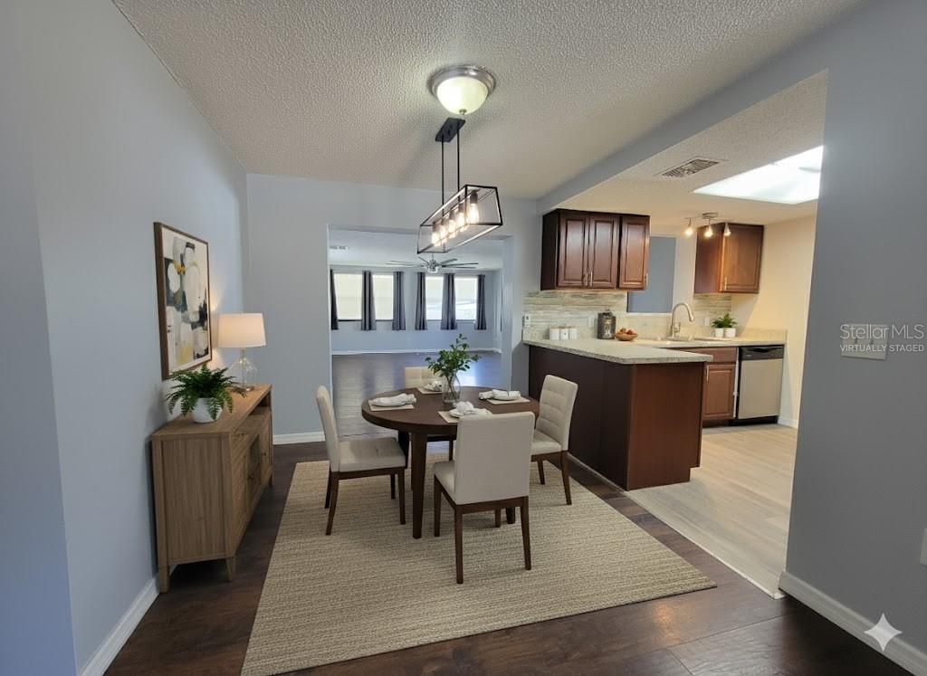 12427 Willow Tree Avenue Hudson, FL 34669 - Photo 7 of 27 a dining room with wooden floor a chandelier a wooden table and chairs