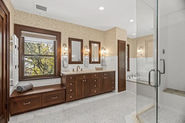 a spacious bathroom with a granite countertop tub sink shower and mirror