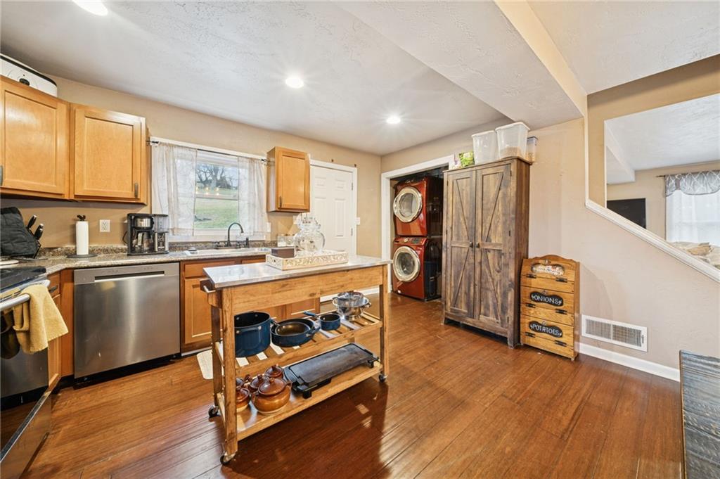 869 Middletown Road New Stanton, PA 15672 - Photo 6 of 30 a kitchen with stainless steel appliances granite countertop a refrigerator a stove a sink and white cabinets with wooden floor