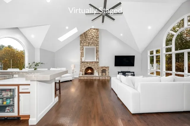 a living room with furniture a flat screen tv and a large window