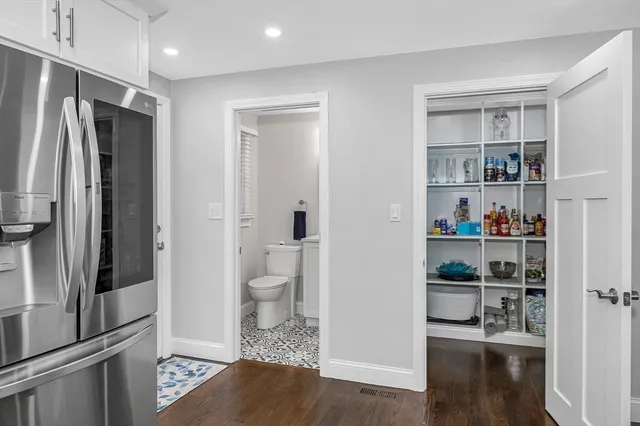 a living room with stainless steel appliances furniture and a flat screen tv