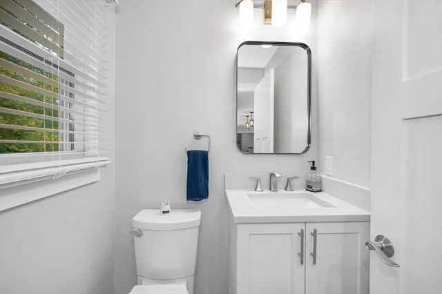 a bathroom with a toilet sink and mirror