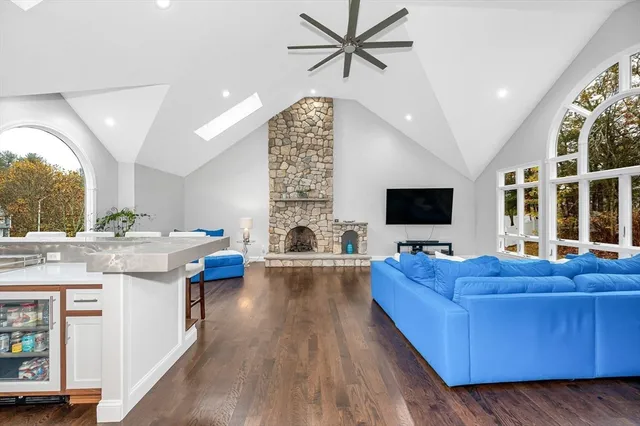 a living room with stainless steel appliances furniture and a flat screen tv