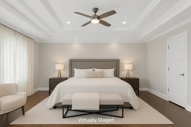 a bedroom with a bed painting on wall and a large window