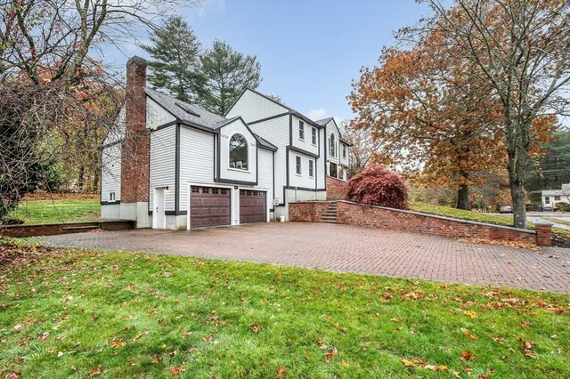 front view of a house with a yard and an trees