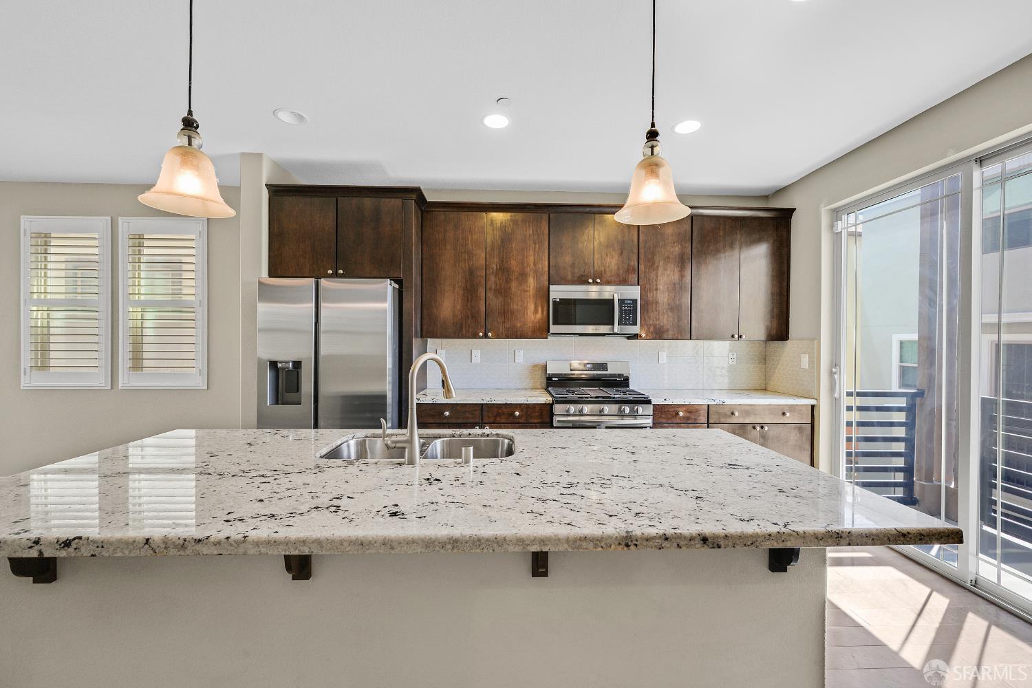 2908 Worthing Common Livermore, CA 94550 - Photo 9 of 33 a kitchen with granite countertop a sink a center island a stove and a window