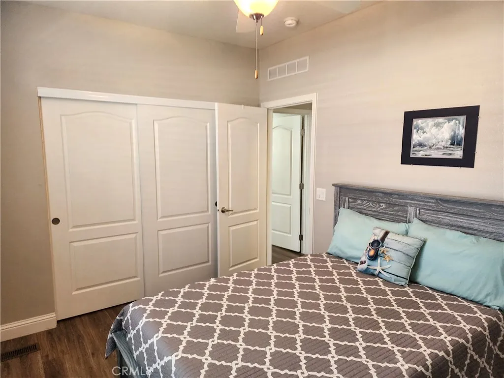 500 Atascadero, Unit E02 Morro Bay, CA 93442 - Photo 27 of 40 a large bed sitting in a bedroom next to a cabinet and a lamp