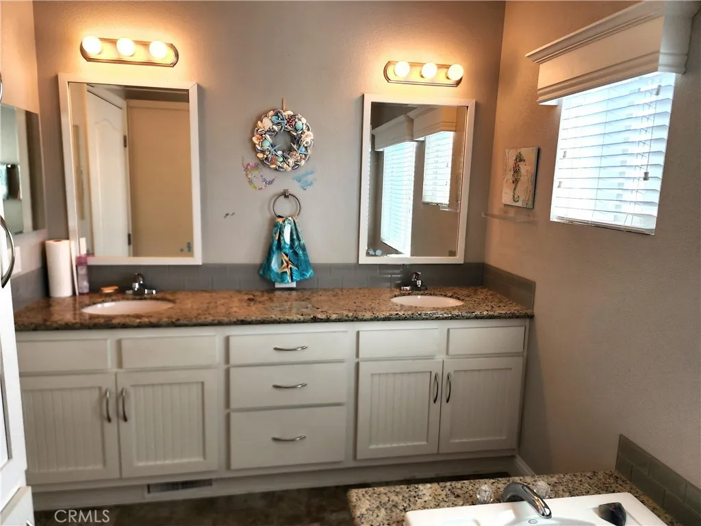 500 Atascadero, Unit E02 Morro Bay, CA 93442 - Photo 37 of 40 a bathroom with a granite countertop sink and a mirror