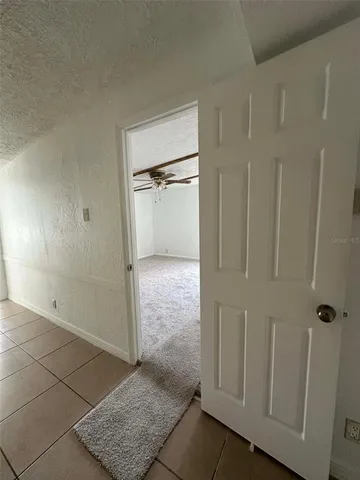 an empty room with windows and ceiling fan