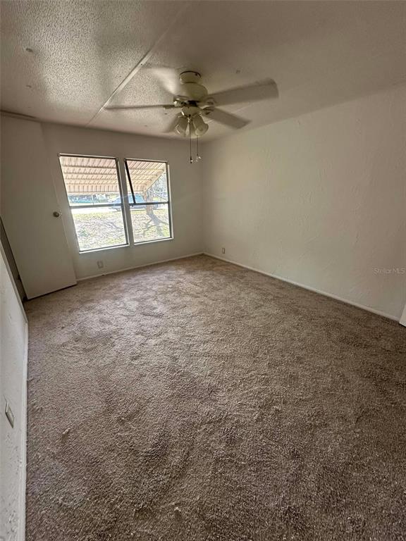 6445 Southeast 173 Lane Summerfield, FL 34491 - Photo 30 of 42 an empty room with windows and ceiling fan