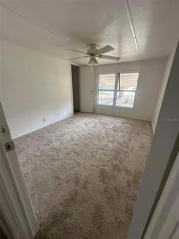 6445 Southeast 173 Lane Summerfield, FL 34491 - Photo 31 of 42 en empty room with windows and ceiling fan