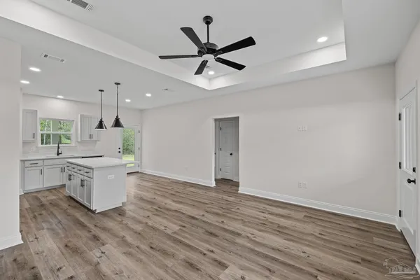 a kitchen with a wooden floor and white cabinets