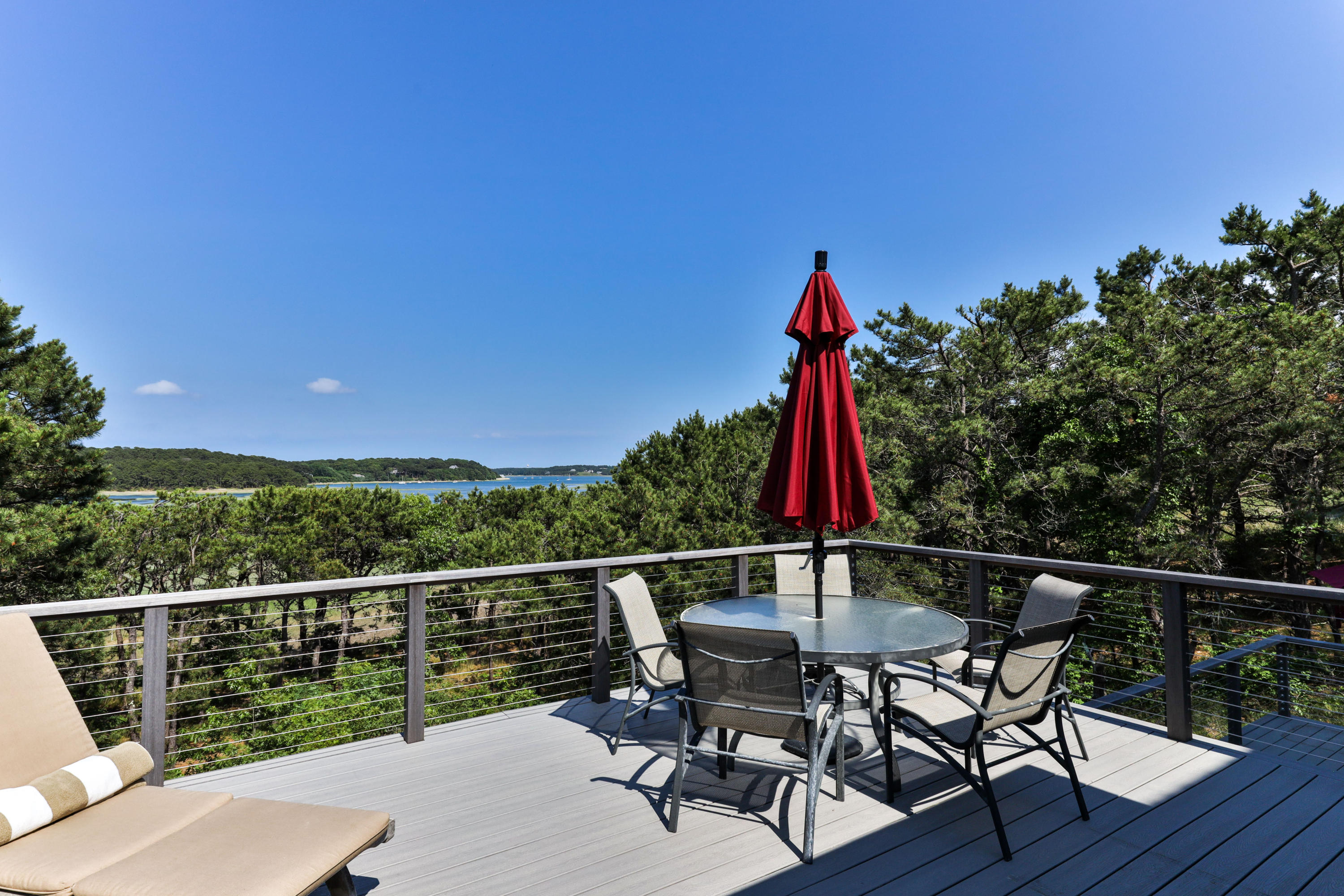 265 King Phillip Road Wellfleet, MA 02667 - Photo 22 of 85 a view of a deck with a table and chairs with wooden floor and fence