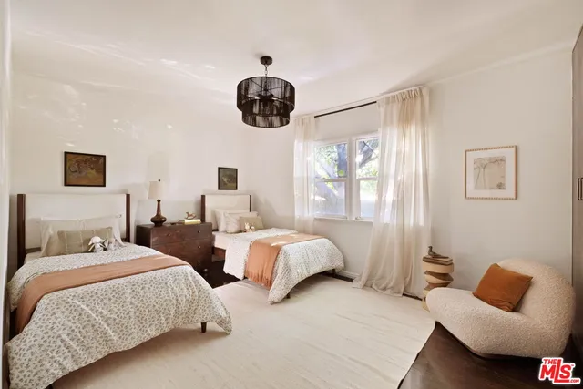 a bedroom with two beds and a large mirror