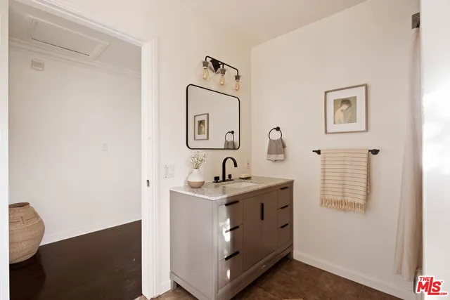 a bathroom with a granite countertop sink a mirror and vanity