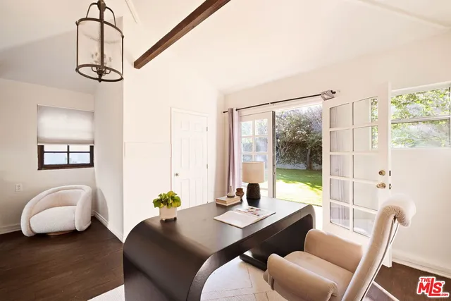 a view of a workspace with furniture and a window