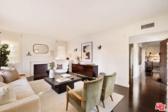 a living room with furniture a fireplace and a wooden floor