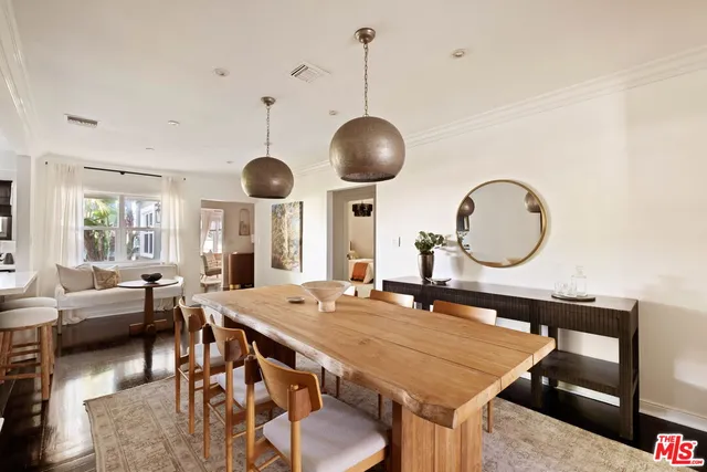 a dining room with wooden floor a chandelier a wooden table and chairs