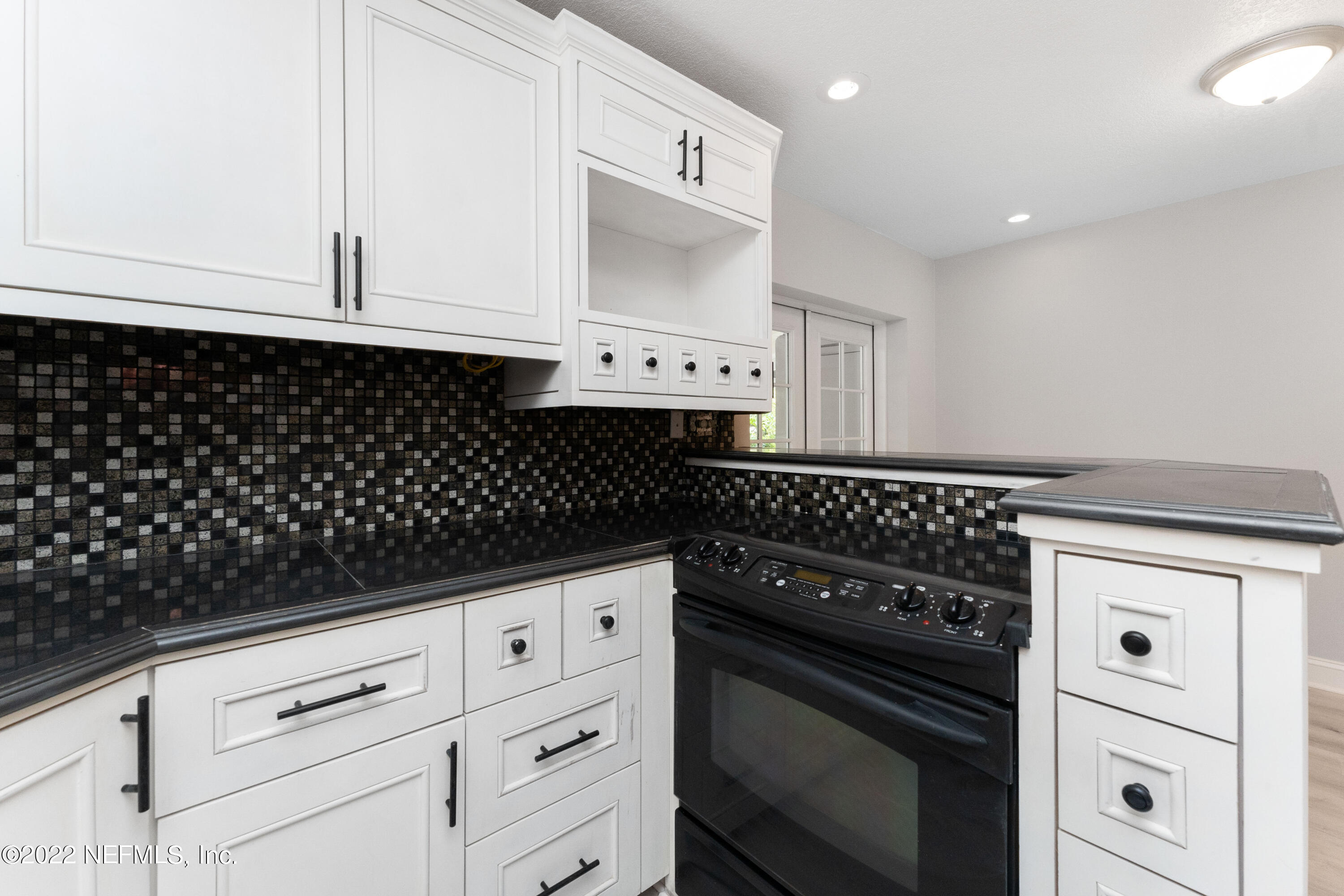 6216 Temple Road Jacksonville, FL 32217 - Photo 10 of 25 a kitchen with white cabinets and black appliances
