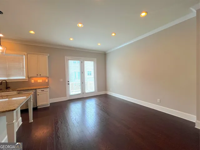 a view of room with stainless steel appliances wooden floor and view living room