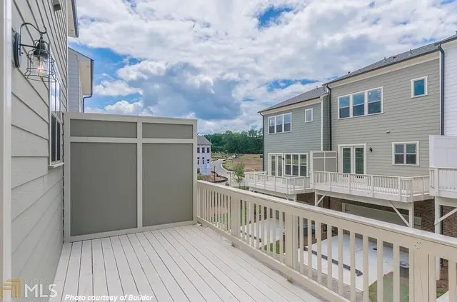 a view of balcony with small yard and wooden fence