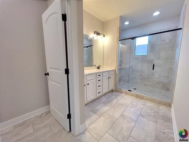 a bathroom with a glass shower door and a sink