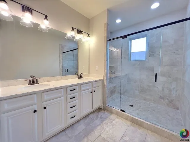 a bathroom with a shower sink and mirror