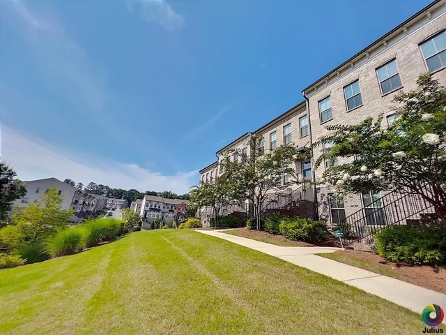 a view of a patio with table and chairs under an umbrella with a small yard