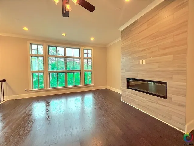 a view of a livingroom with wooden floor and a ceiling fan