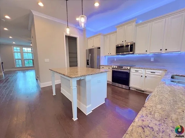 a kitchen with stainless steel appliances granite countertop a stove and a refrigerator