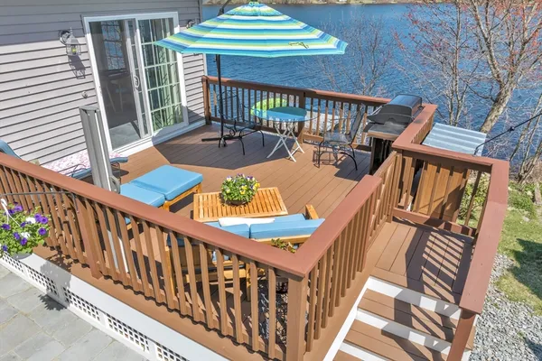 a balcony with wooden floor stairs and outdoor seating
