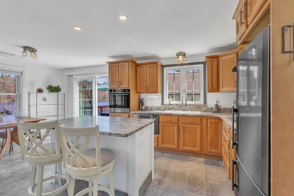 a kitchen with granite countertop lots of white cabinets and stainless steel appliances