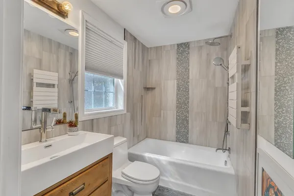 a bathroom with a sink a toilet tub and shower