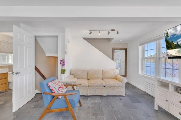 a living room with furniture a flat screen tv and a window