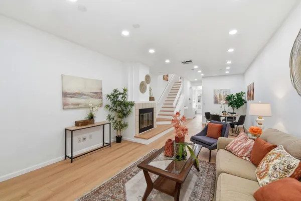a living room with furniture a fireplace and a chandelier
